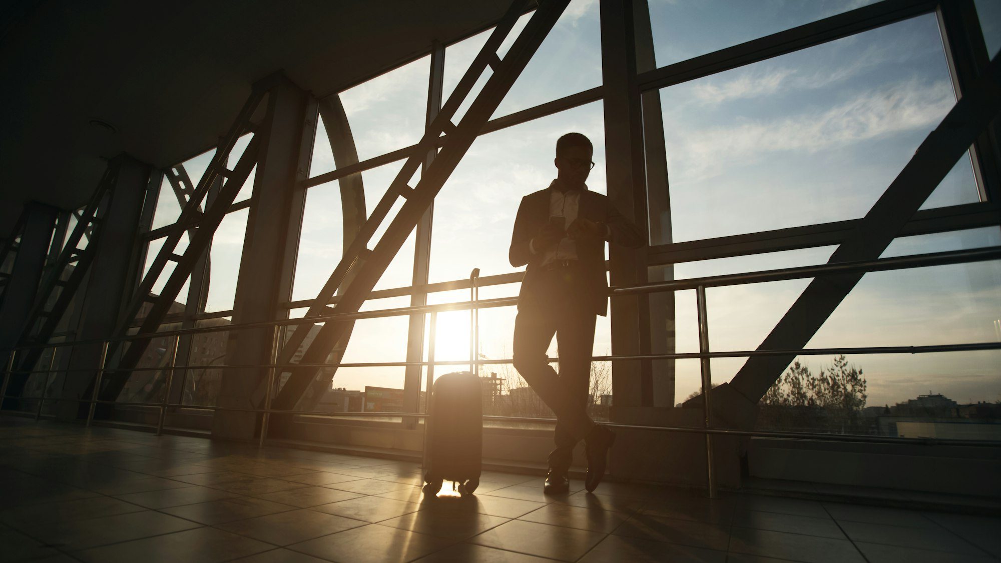 african businessman with suitcase waiting for plane in airport panorama