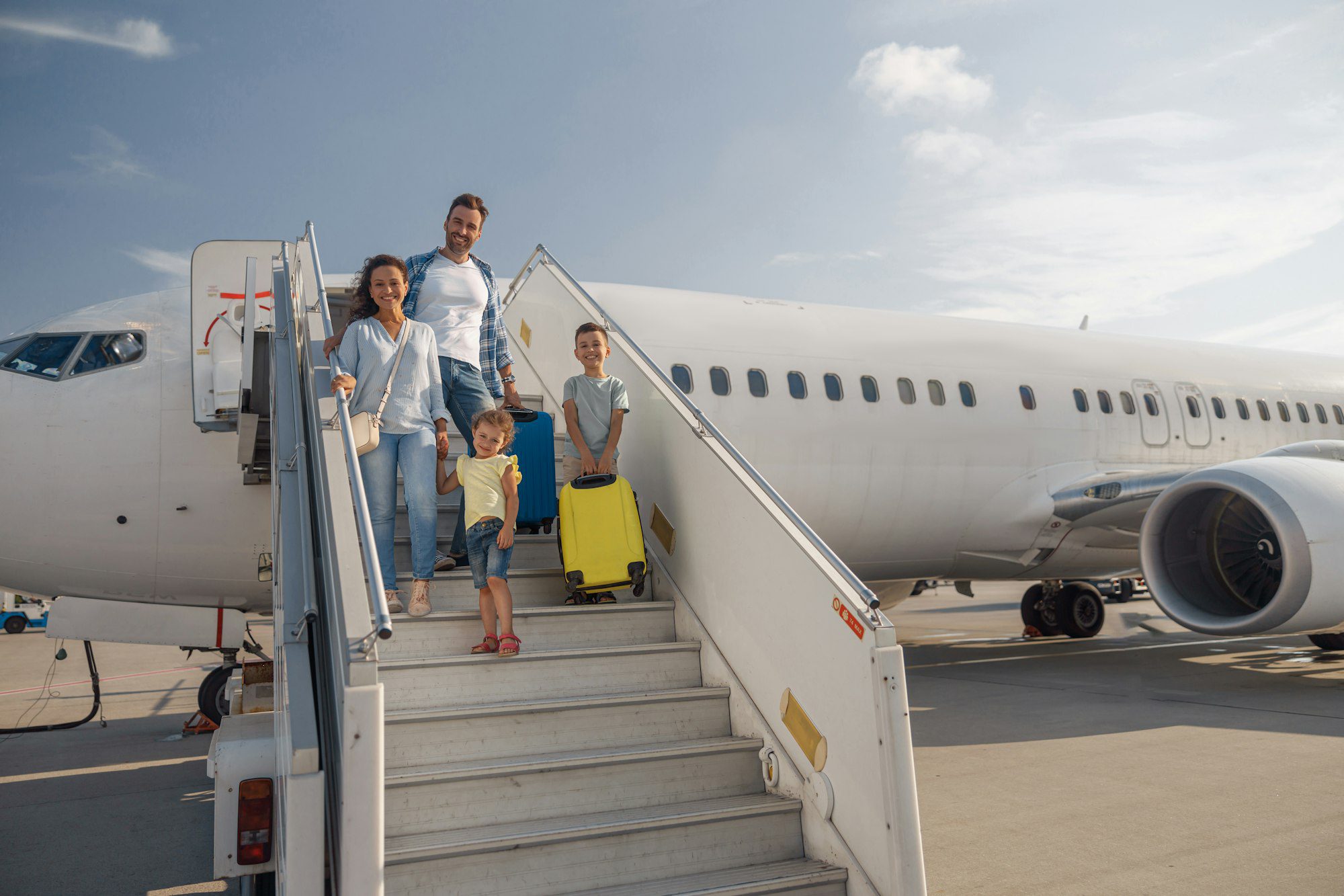 happy family of four getting off the plane on a daytime