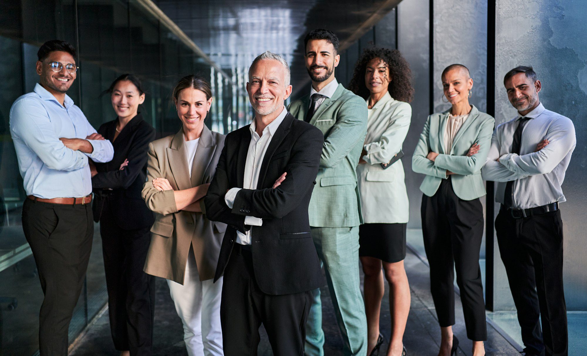 Équipe commerciale multiculturelle dirigée par le patron. Posant joyeusement devant la caméra au bureau.