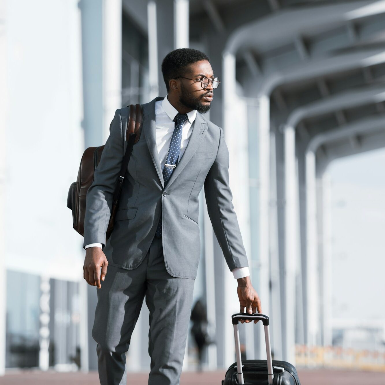 Homme d'affaires africain sérieux voyageant en voyage d'affaires à pied près de l'aéroport