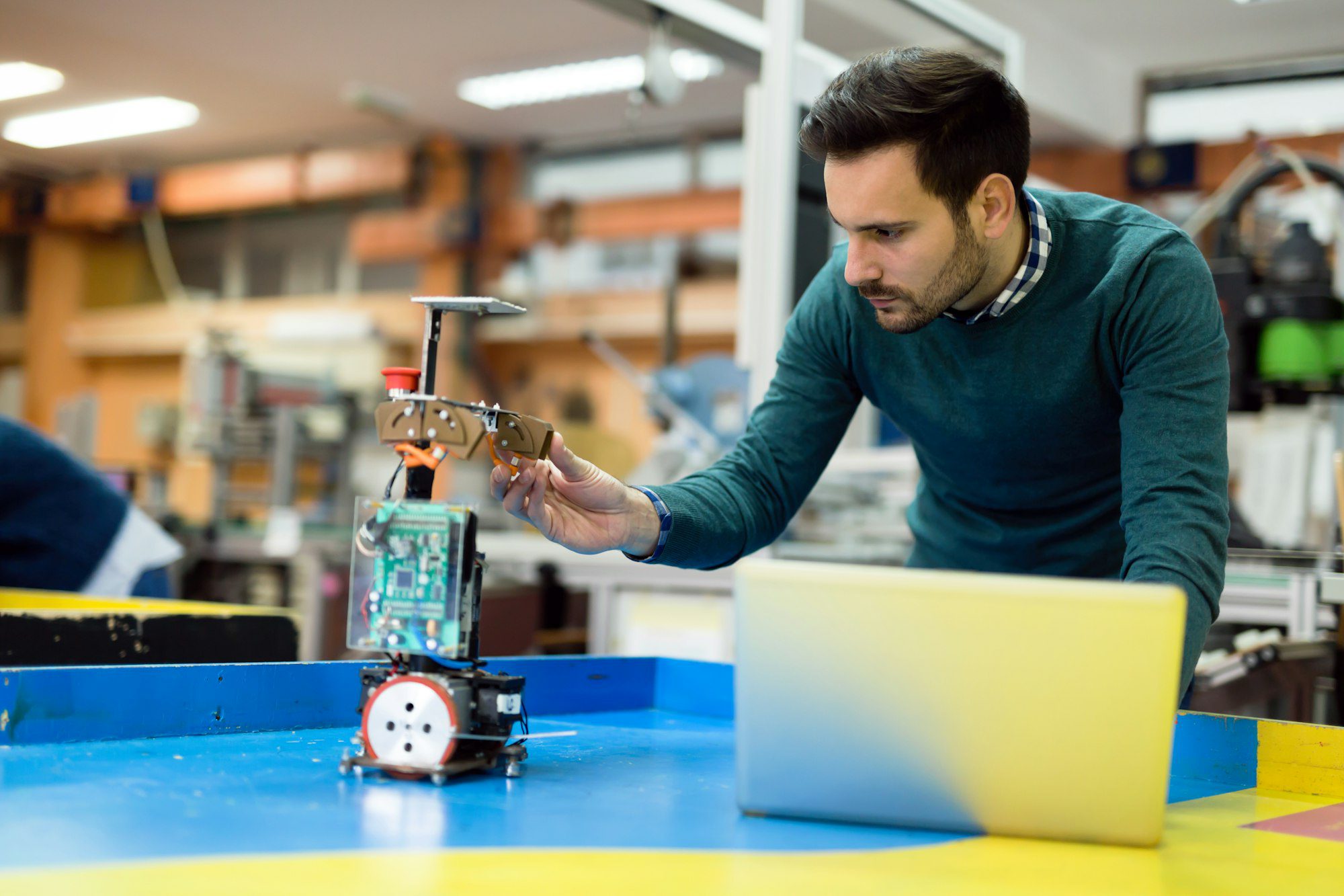 young engineer testing his robot in workshop